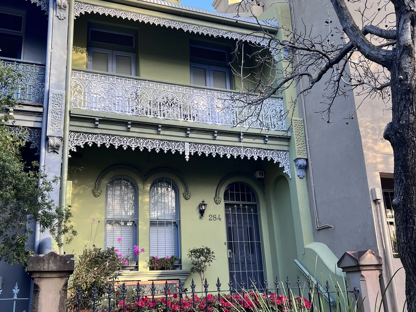 Green two-storey Victorian terrace with cast-iron lace and arched windows, Darlington